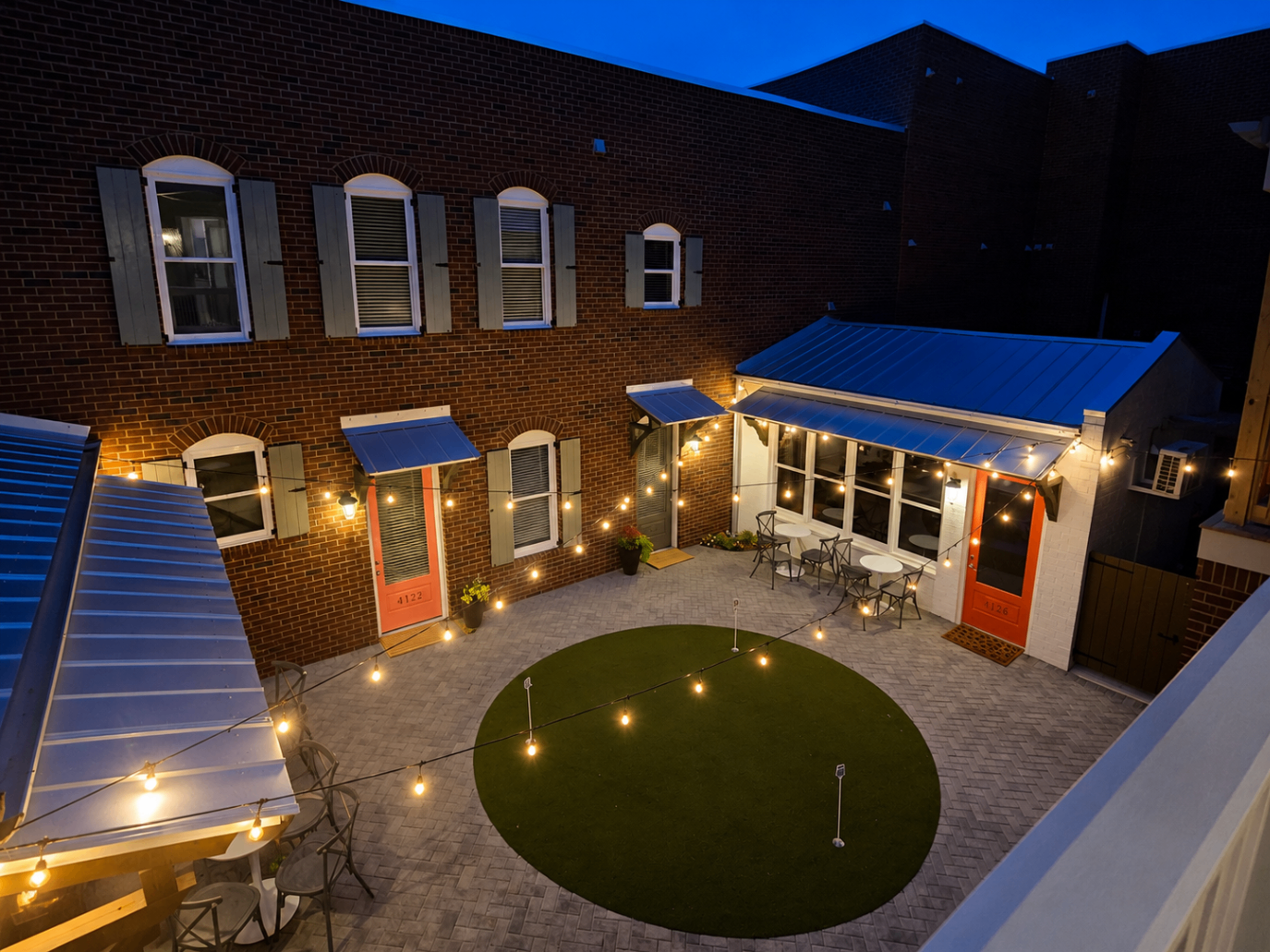 Caulker House courtyard at twilight with warm string lights